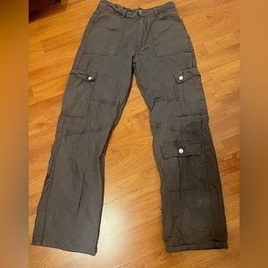 Grey cargos with pockets all over the front of it and visible grey seams.